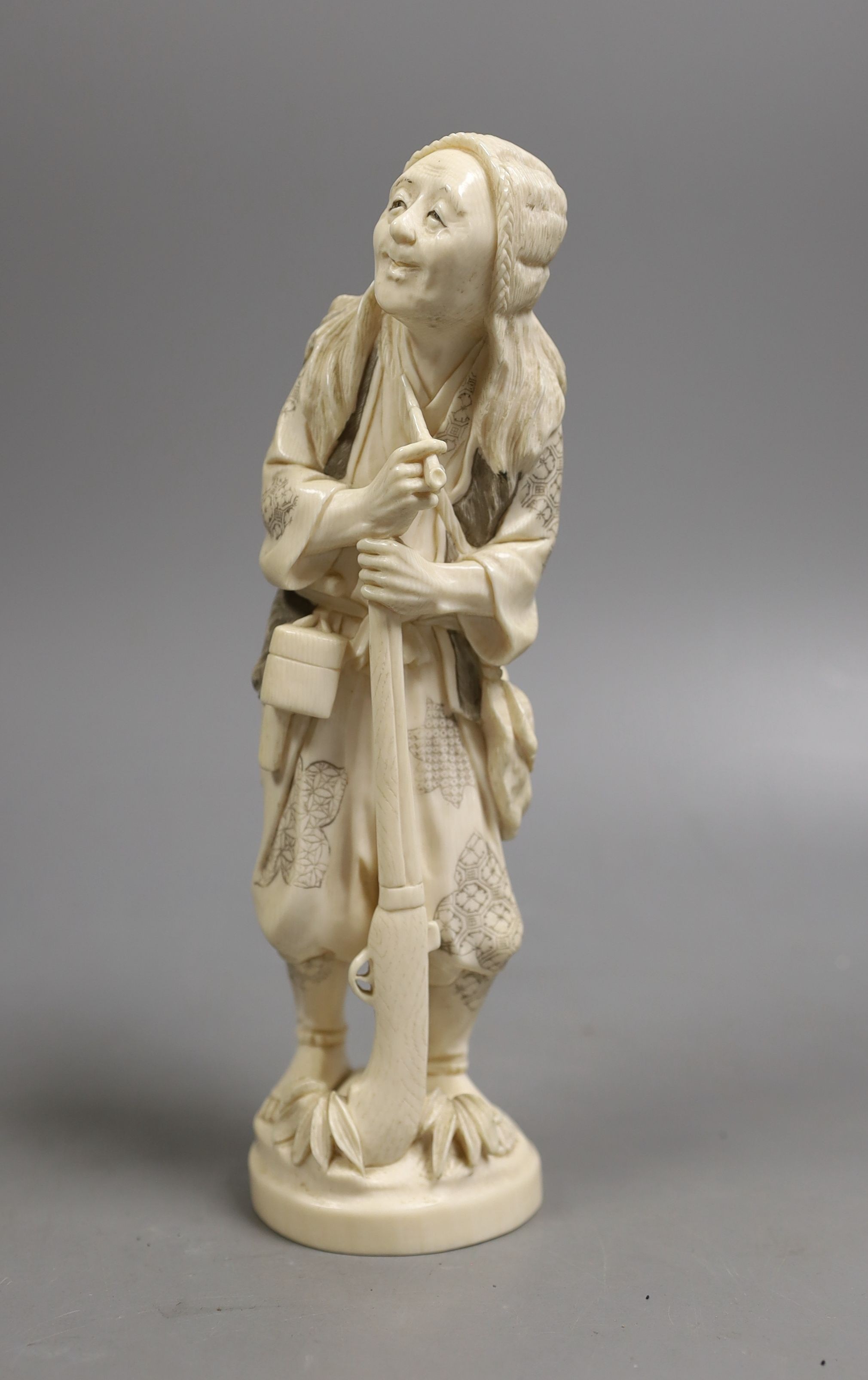 A Japanese ivory figure of a huntsman, early 20th century, 21 cms high.